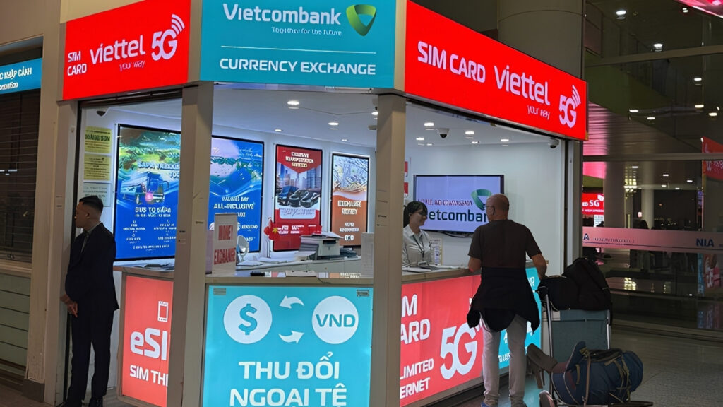 Vietnam SIM Card & Internet Guide (2026): What Actually Works for Travelers 5 Traveler using mobile internet outside Hanoi airport at night