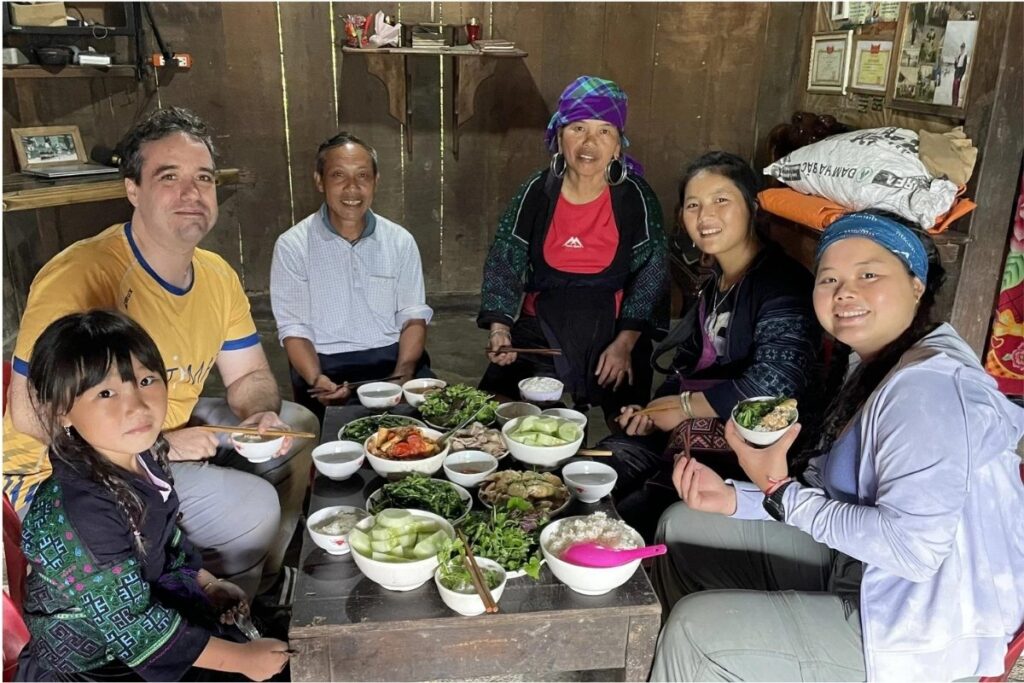 Travelers sharing dinner with a local ethnic family in Vietnam