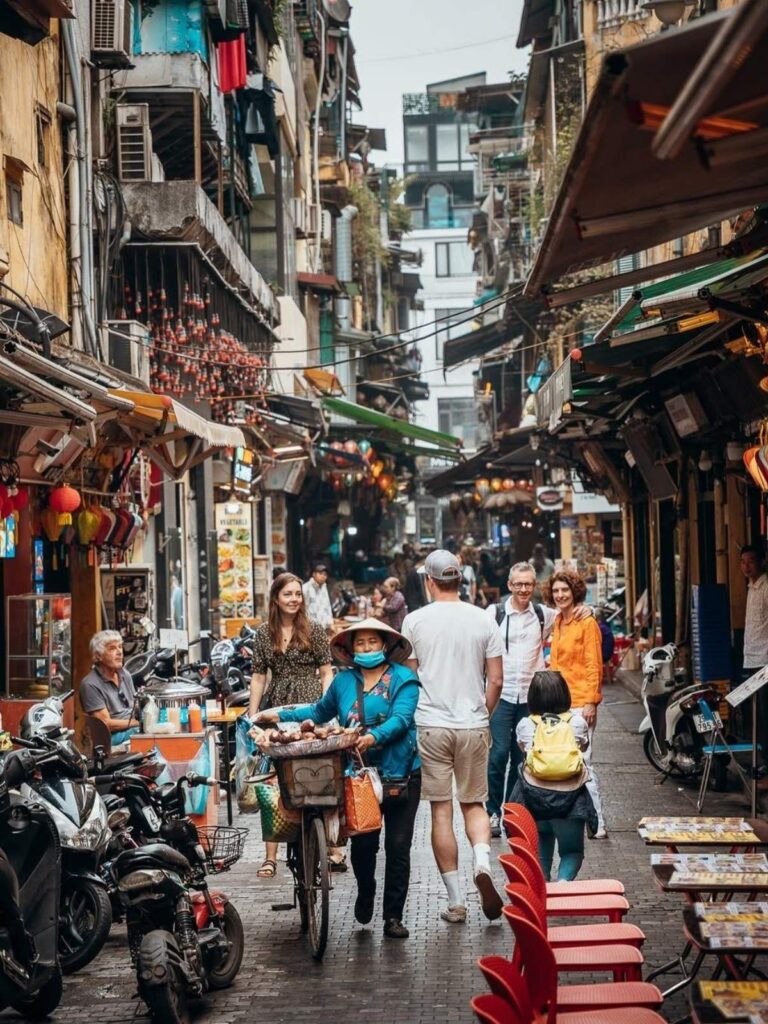 Vietnamese Etiquette Guide: 25 Cultural Tips Every Traveler Should Know Before Visiting Vietnam 11 Travelers walking along a busy street in Hanoi