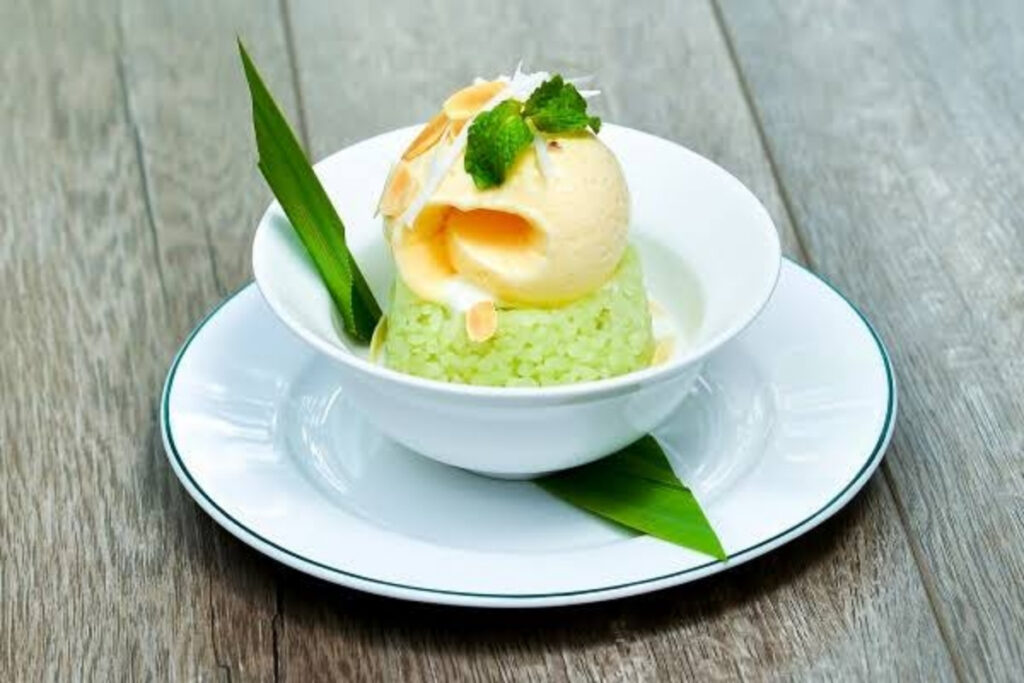 Best Vietnamese Desserts: 20 Sweet Treats Every Traveler Should Try in Vietnam 20 Traditional Hanoi kem xôi dessert with vanilla ice cream, warm sticky rice, toasted coconut flakes, and roasted peanuts.