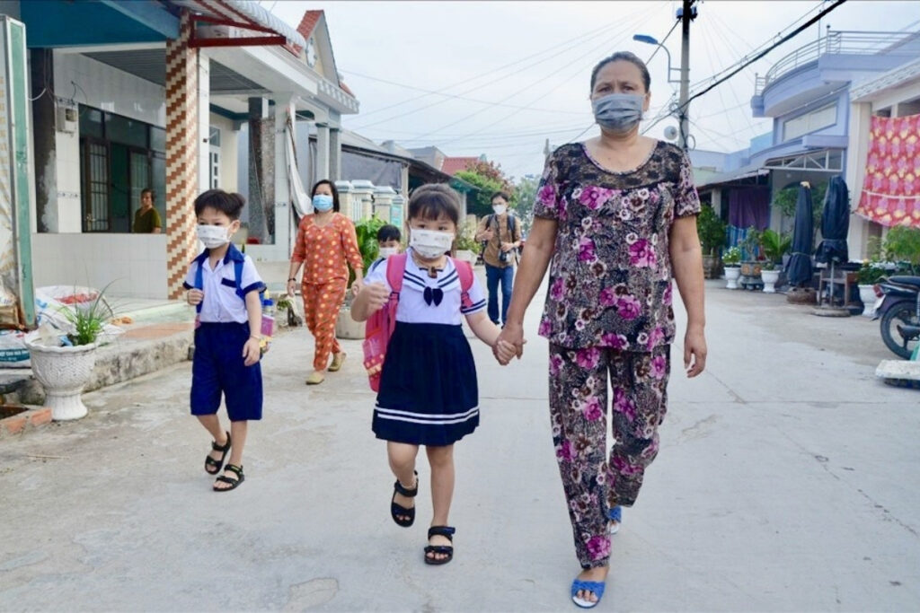 Vietnamese grandparents walking grandchildren to school