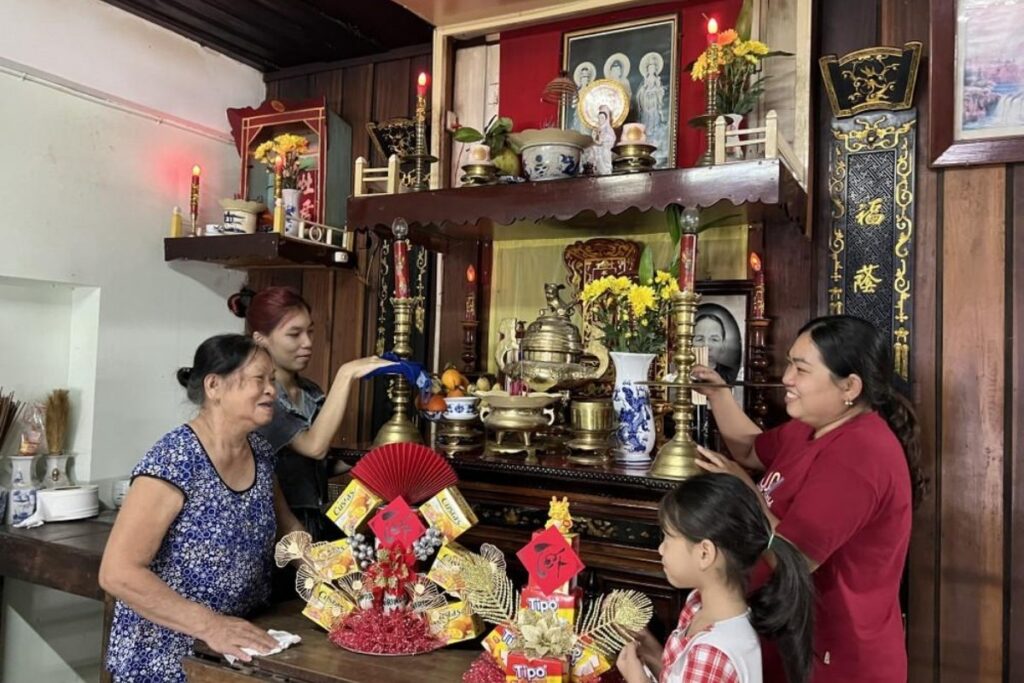 Ancestor Worship in Vietnam: Understanding the Spiritual Tradition That Shapes Vietnamese Life 2 Vietnamese family lighting incense at a home ancestor altar