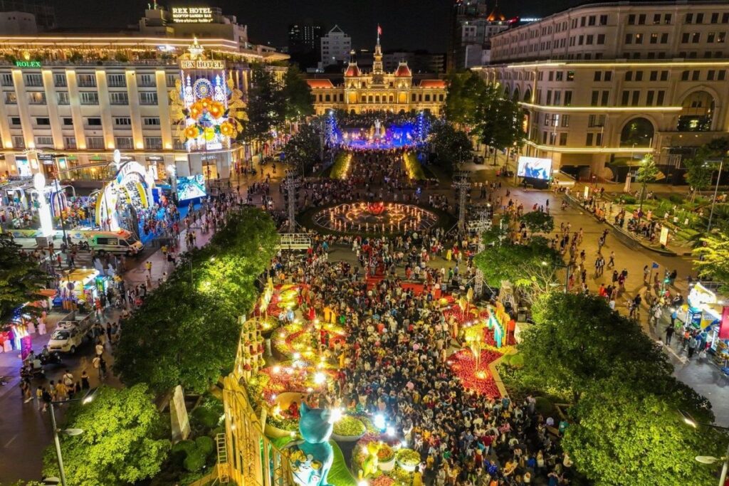 Tet Holiday in Vietnam: Traditions, Food, Customs, and How Vietnamese Celebrate Lunar New Year 3 Visitors walking along Nguyen Hue Flower Street during Tet in Ho Chi Minh City