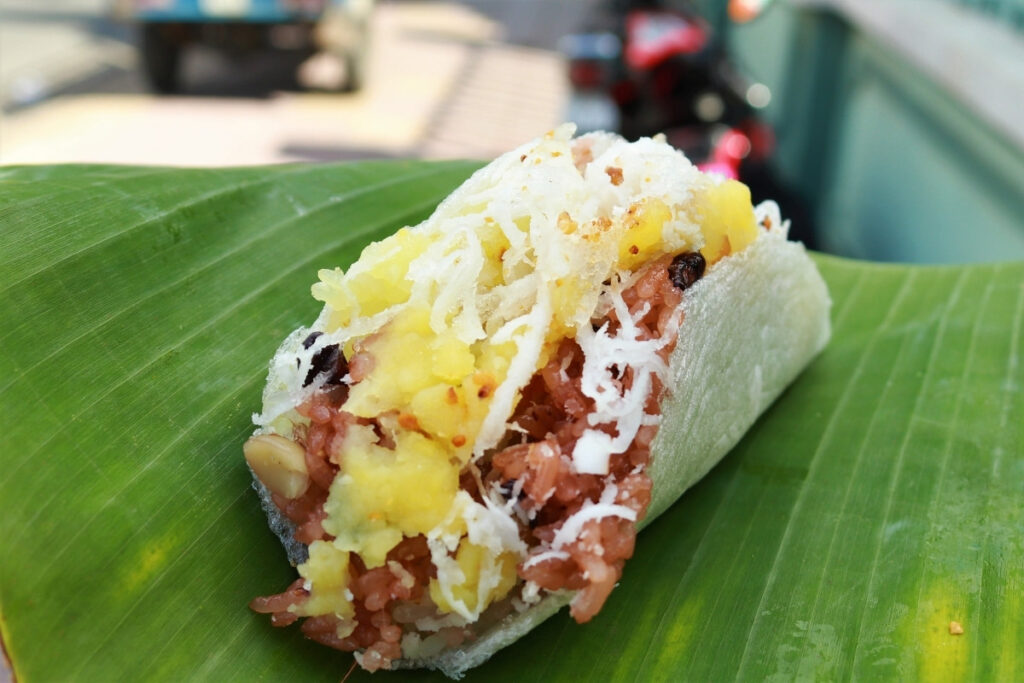 Best Vietnamese Desserts: 20 Sweet Treats Every Traveler Should Try in Vietnam 7 Vietnamese sweet sticky rice topped with mung beans, shredded coconut, roasted sesame seeds, and peanuts served on a banana leaf.
