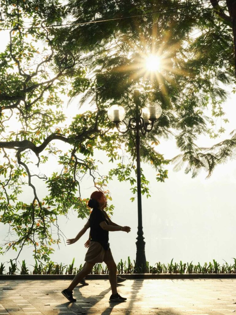 Residents practicing tai chi beside Hoan Kiem Lake in Hanoi at sunrise