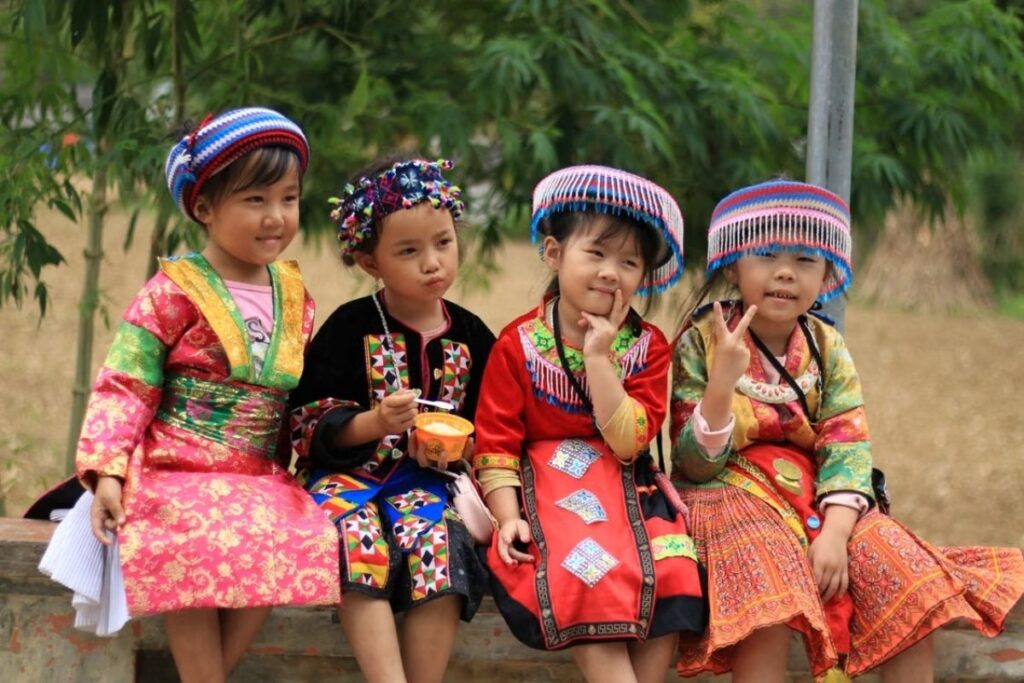 Children from different ethnic communities sitting together near fields of northern Vietnam