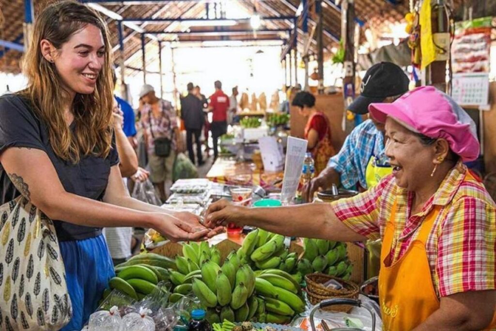 Vietnamese Etiquette Guide: 25 Cultural Tips Every Traveler Should Know Before Visiting Vietnam 3 Traveler chatting with a Vietnamese market vendor
