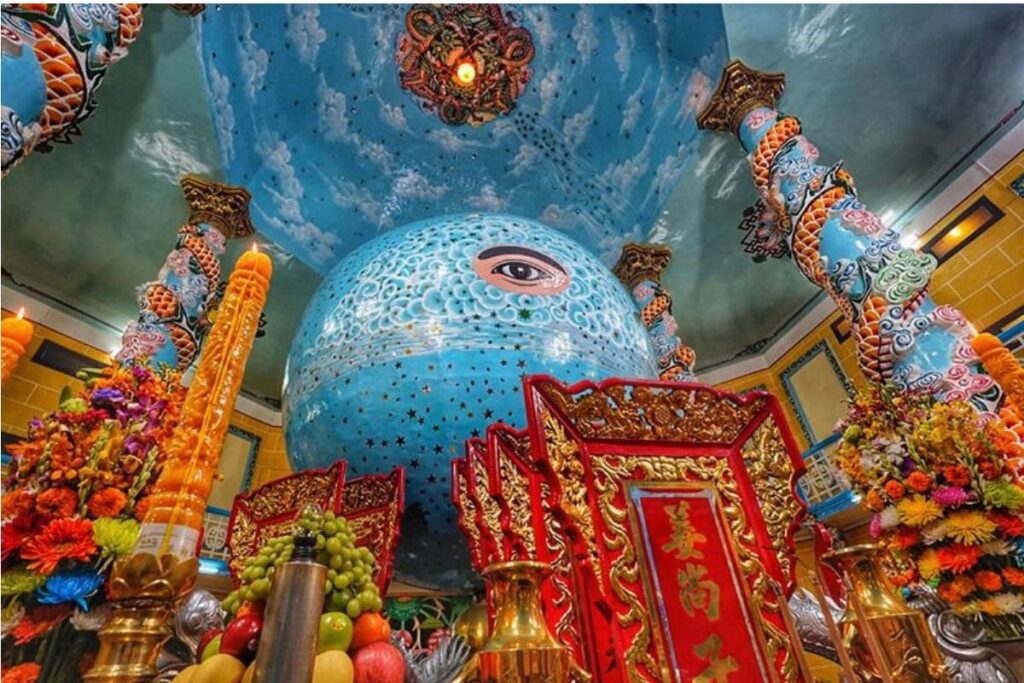 Vietnamese Religion & Beliefs: A Complete Guide to Faith, Spirituality, and Daily Life in Vietnam (2026) 9 Worshippers praying beneath the Divine Eye inside Tây Ninh Holy See