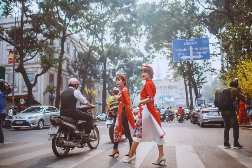 Pedestrians crossing a busy street in Hanoi with motorbikes