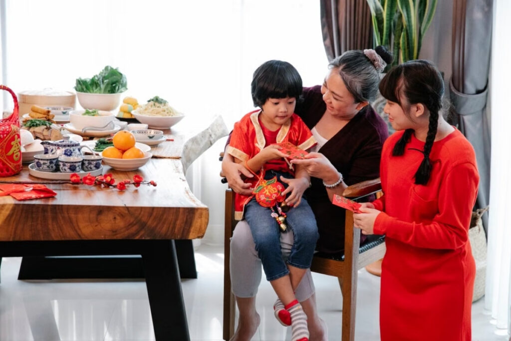 Vietnamese child receiving a red lucky money envelope during Tet