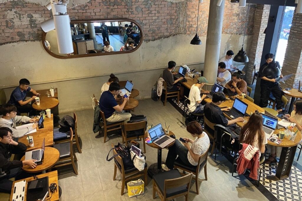 Young people working and drinking coffee at a modern cafe in Vietnam