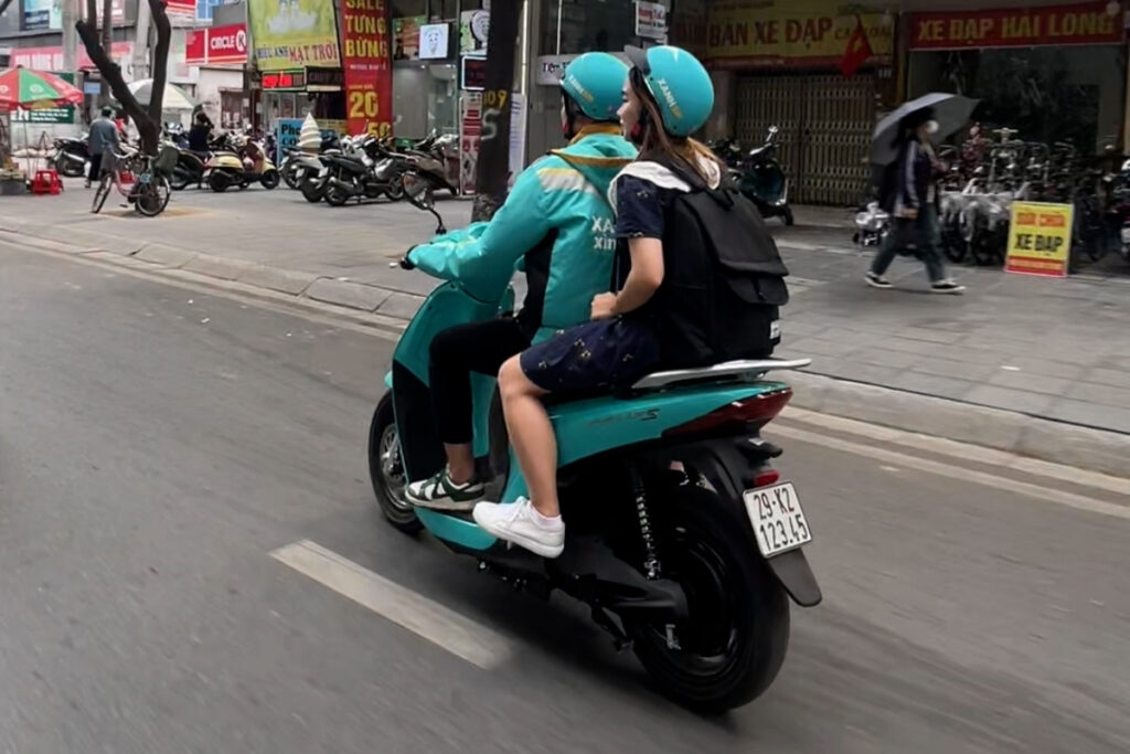 Traveler riding as a passenger on a motorcycle taxi in Vietnam