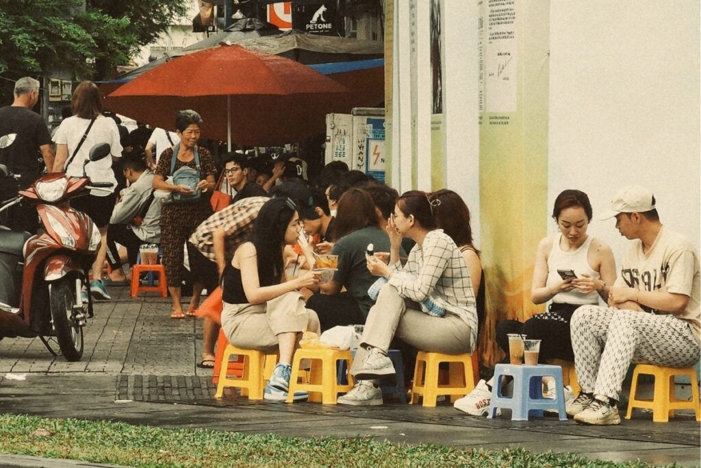 Vietnamese people socializing at a sidewalk cafe in the morning
