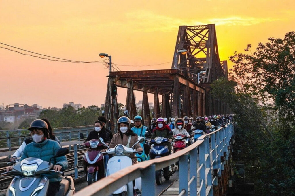Motorbikes moving through a busy Vietnamese street in the evening