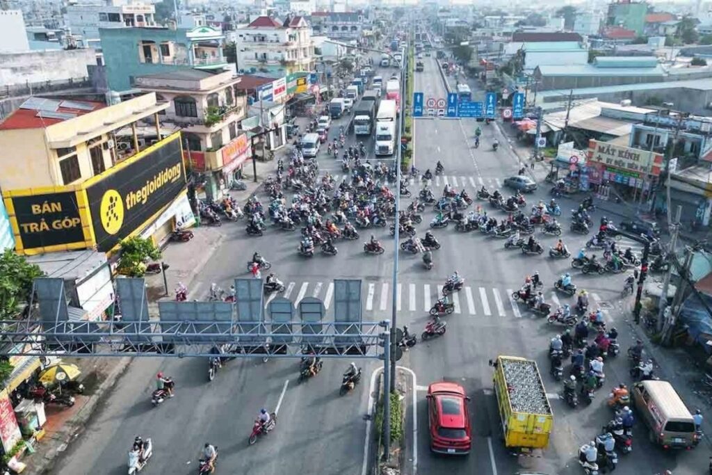 Motorbike traffic and pedestrians navigating a busy Vietnamese city street