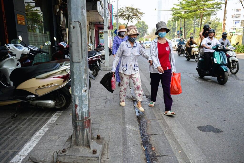 Pedestrians and motorbikes sharing limited street space in Vietnam