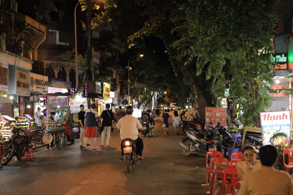 People eating at a sidewalk food stall in Vietnam