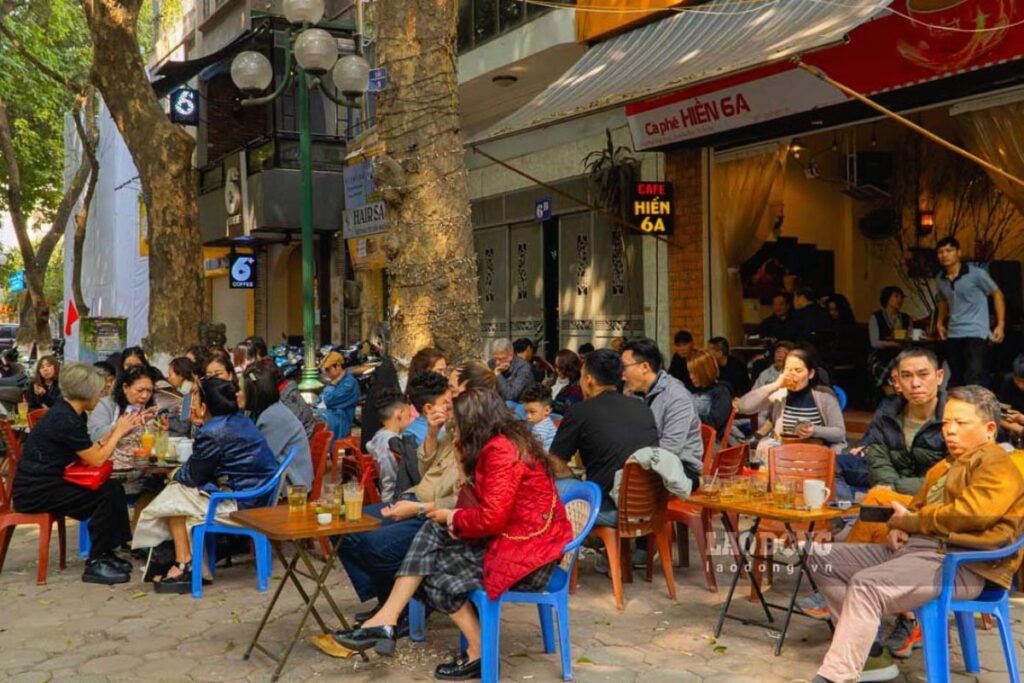Vietnamese people drinking coffee at a sidewalk cafe in the morning