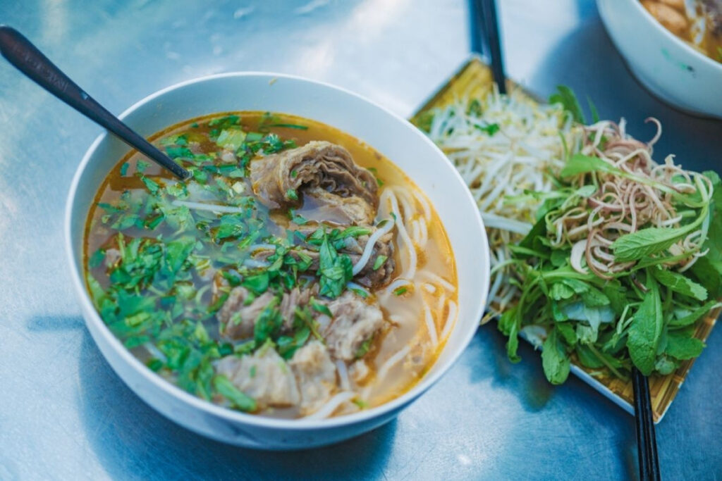 Fresh Vietnamese herbs served alongside a traditional noodle dish