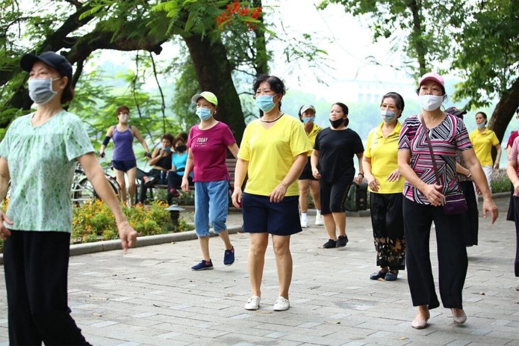 Vietnamese people practicing tai chi at Hoan Kiem Lake in Hanoi