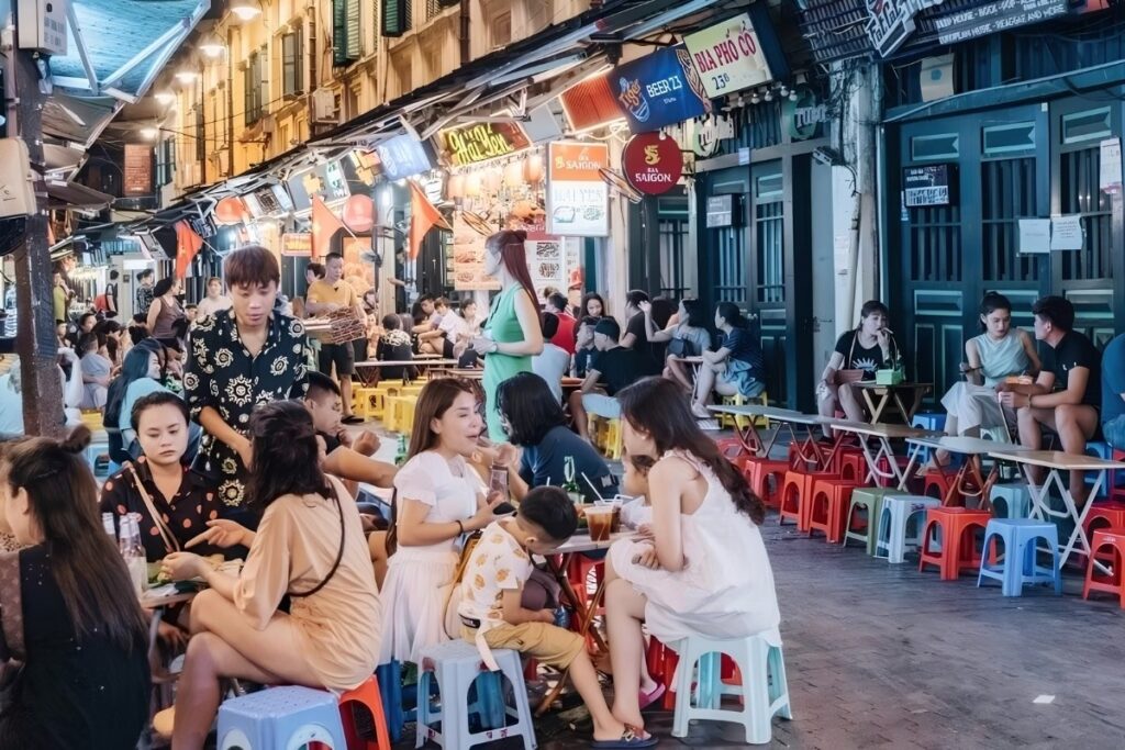 People eating Vietnamese street food on low plastic stools