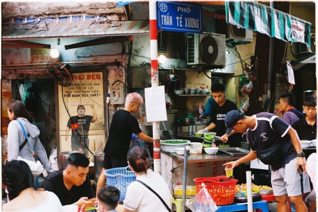 Vietnamese street food vendor serving breakfast on a busy morning