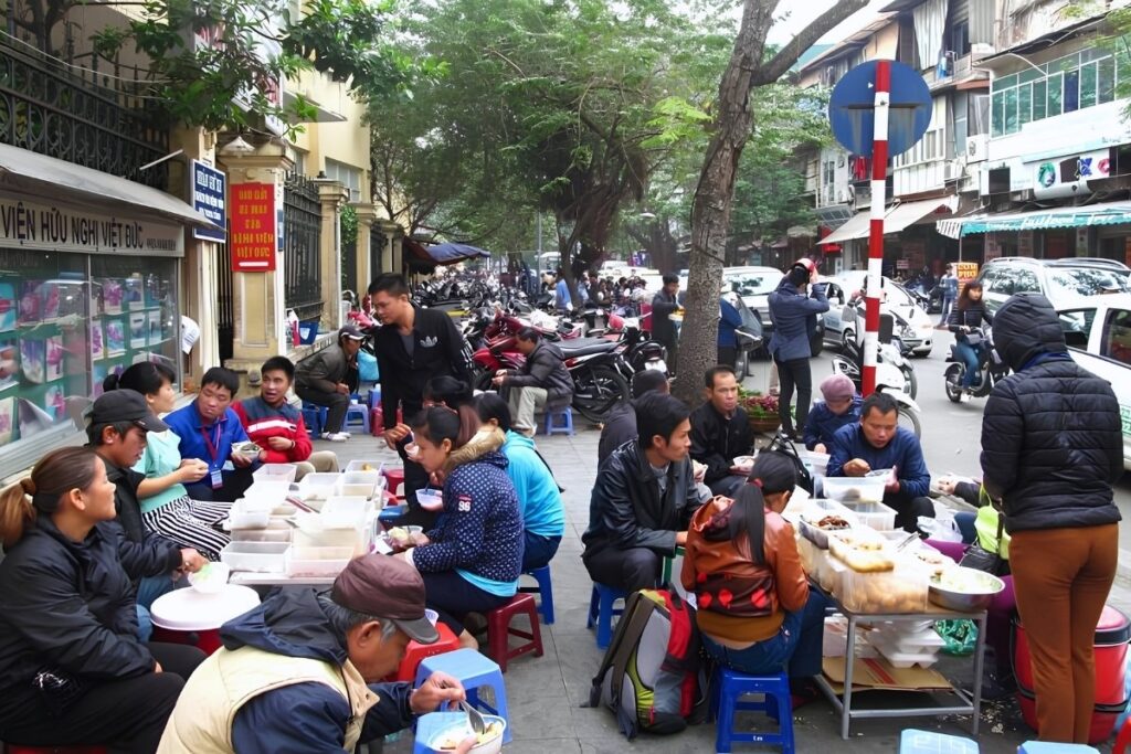 Vietnamese street food served on small plastic stools in Hanoi