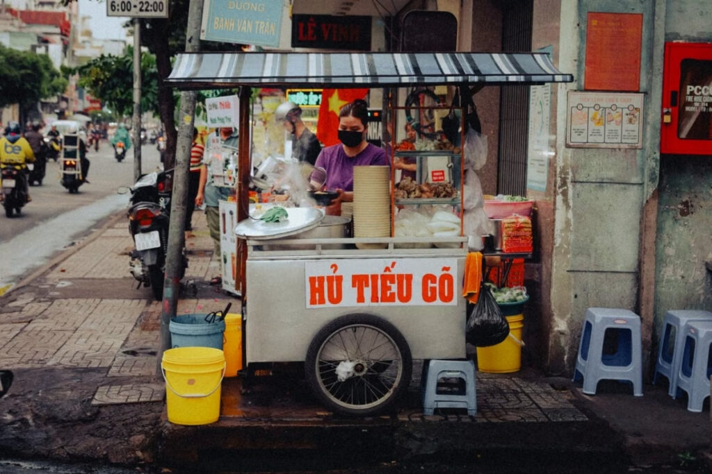 Vietnamese street food vendor preparing food at a family-run stall