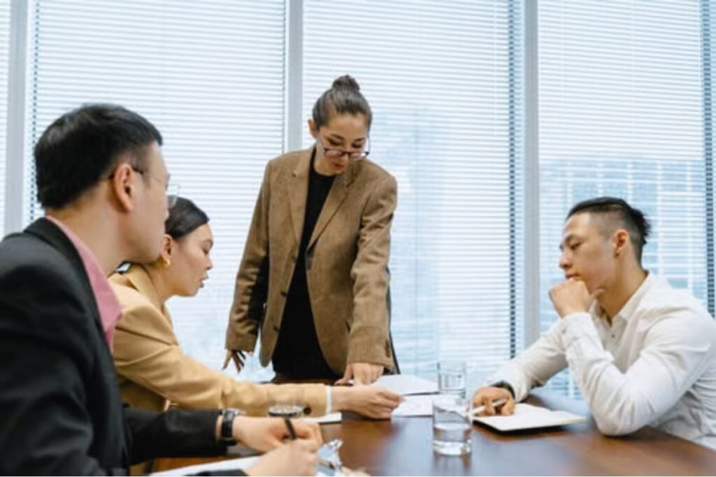 Vietnamese manager speaking with employees during an office meeting