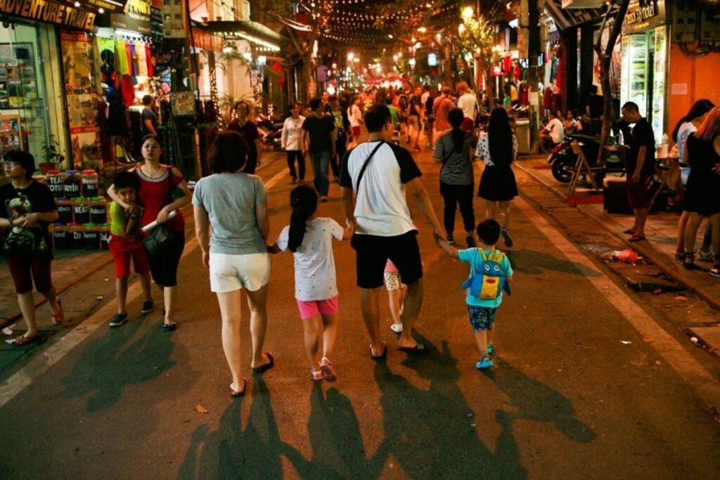Pedestrian walking along an everyday street in Vietnam at evening