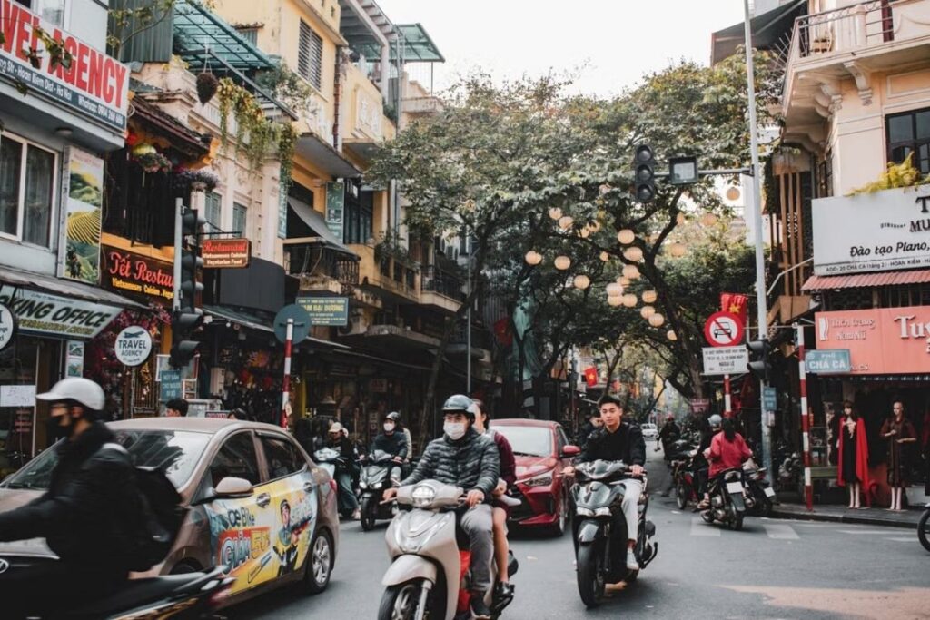 Pedestrians and motorcycles sharing a narrow street in Hanoi's Old Quarter