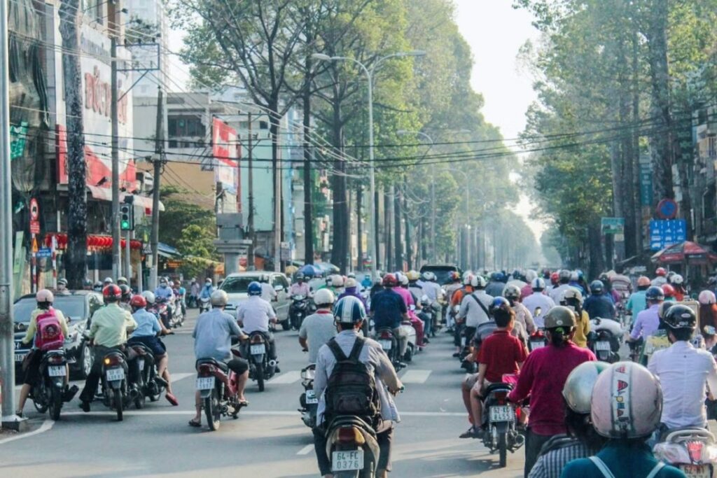 Motorcycles and scooters moving through a busy street in Ho Chi Minh City, Vietnam