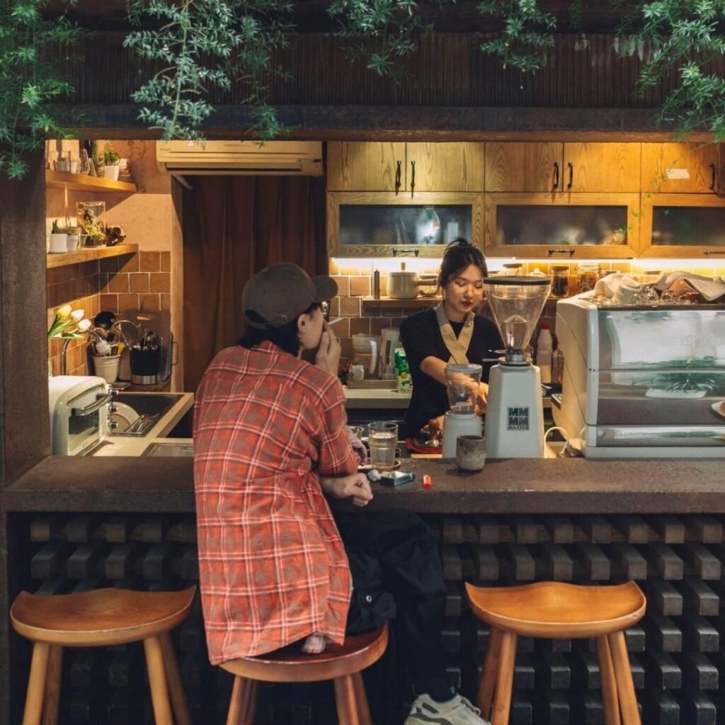 Regular customer being greeted at a neighborhood coffee shop in Vietnam